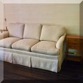 F24. Custom three-cushion sofa. 35”h x 75”w x 38”d 